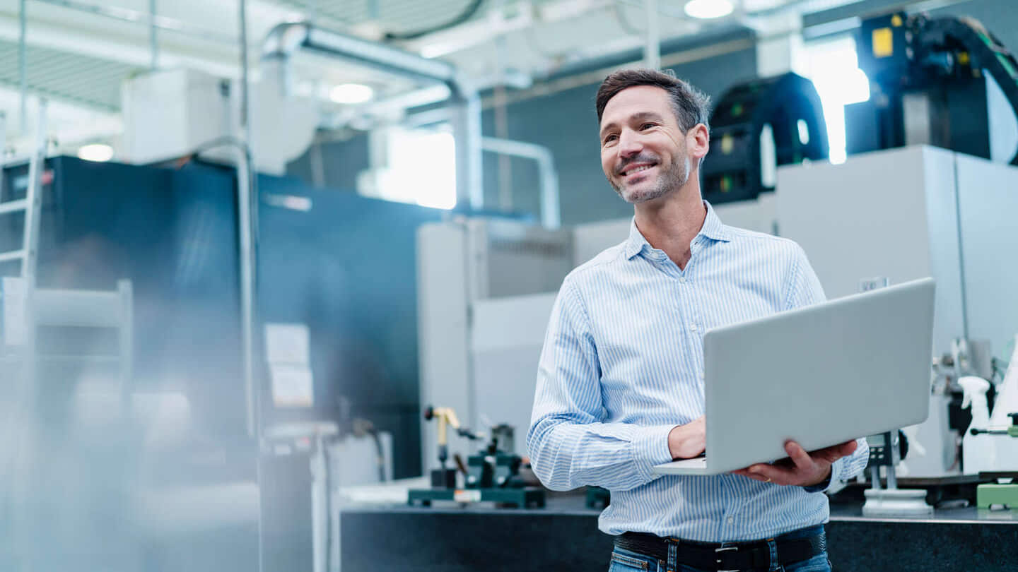 Homme d'affaires tenant un ordinateur portable alors qu'il travaille dans le secteur industriel