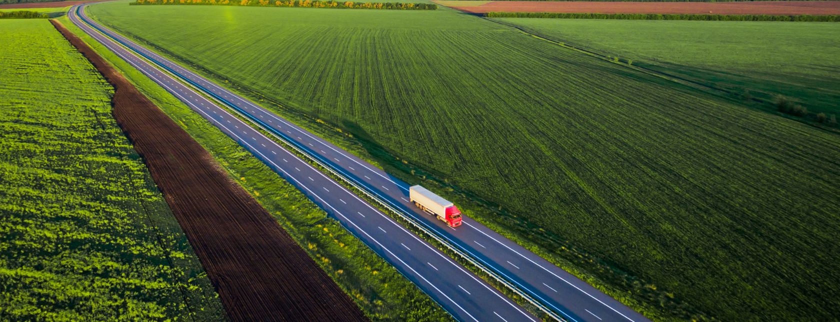 Truck on road between fields