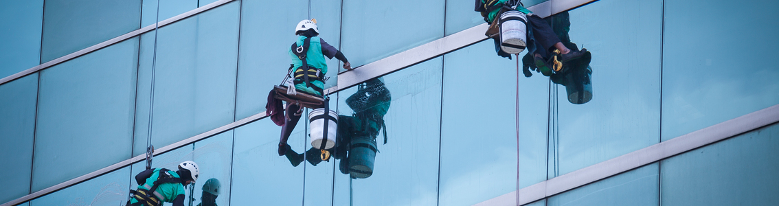 Group of workers cleaning windows service on high rise building
